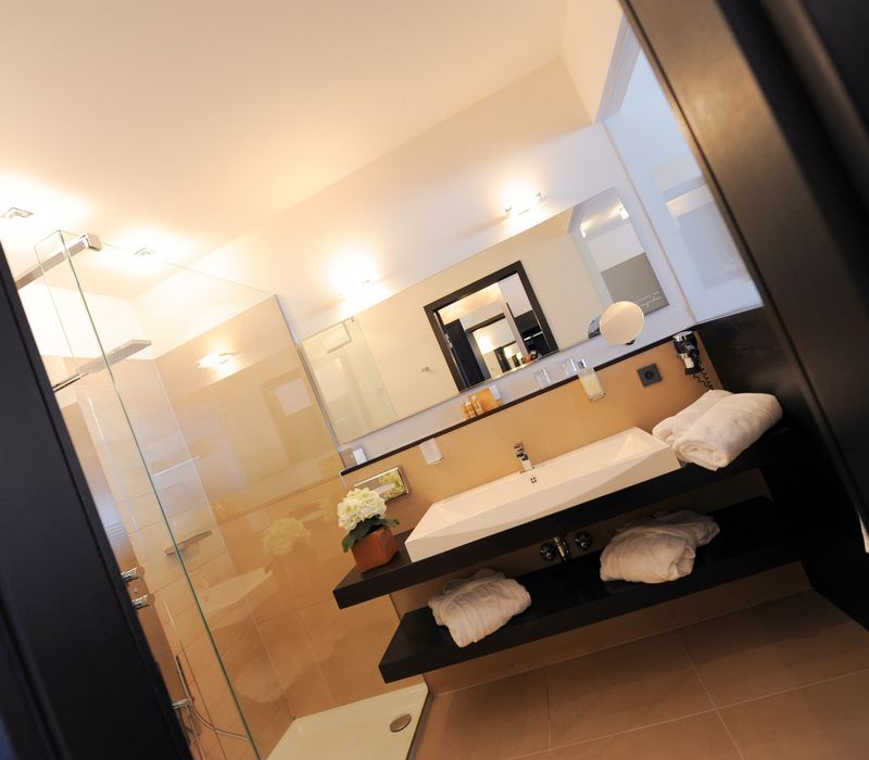 Modernes Penthouse-Badezimmer im Hotel Vier Jahreszeiten in Südtirol mit freistehender Badewanne und stilvoller Einrichtung