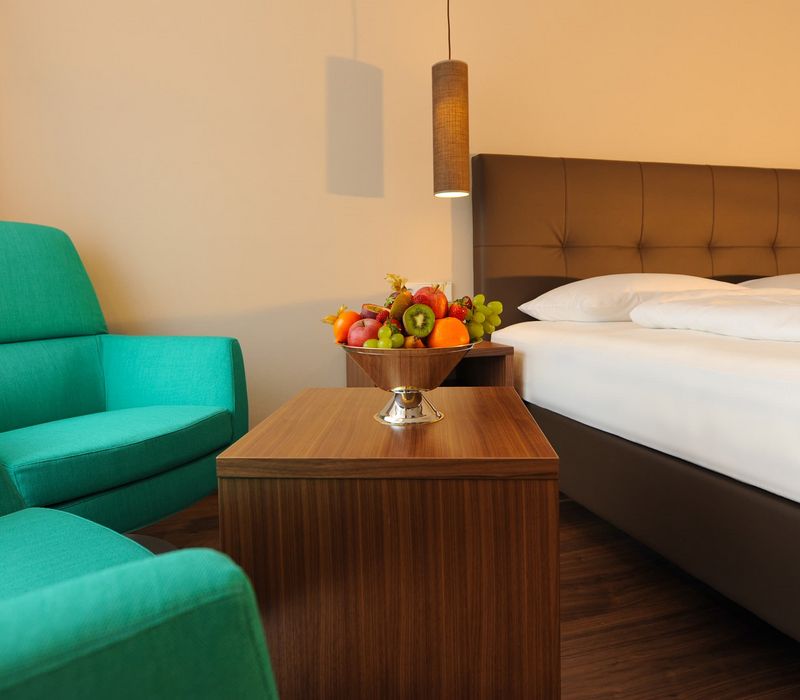 Camera doppia accogliente con letto matrimoniale e angolo salotto all’Hotel Vier Jahreszeiten nelle Alpi