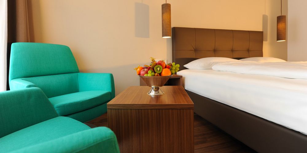 Cozy double room with sitting area and alpine decor at Hotel Vier Jahreszeiten