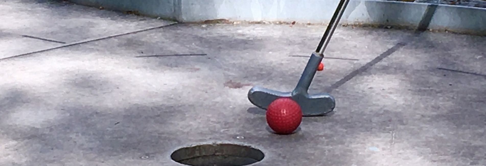 Familien spielen Minigolf im Freien während des Urlaubs im Hotel Vier Jahreszeiten in Südtirol