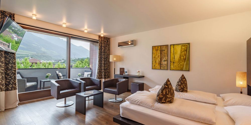 Luxury outdoor pool area at Hotel Vier Jahreszeiten in South Tyrol, surrounded by sun loungers and mountain views