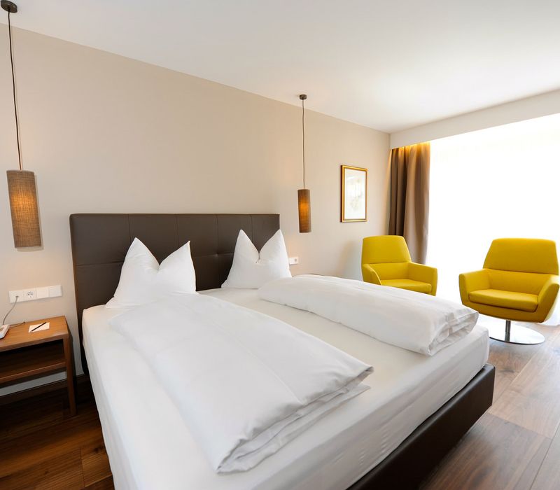 Camera doppia Alpen con letto matrimoniale e angolo salotto all’Hotel Vier Jahreszeiten