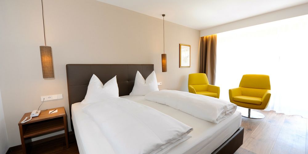 Double room Alpen with double bed and sitting area at Hotel Vier Jahreszeiten South Tyrol