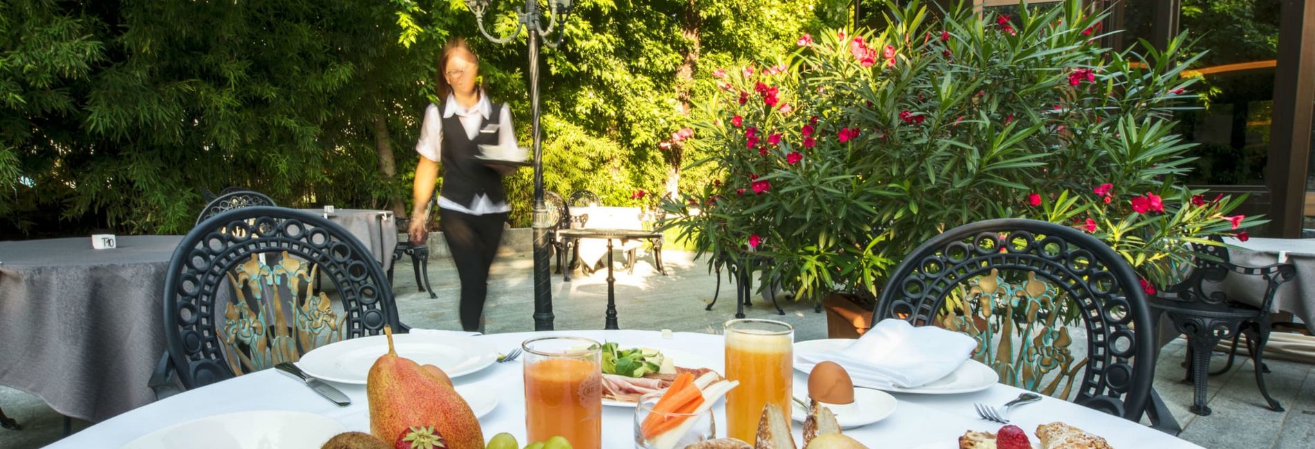 Breakfast on the terrace of Vier Jahreszeiten hotel in South Tyrol with mountain view Breakfast on the terrace of Vier Jahreszeiten hotel in South Tyrol with mountain view