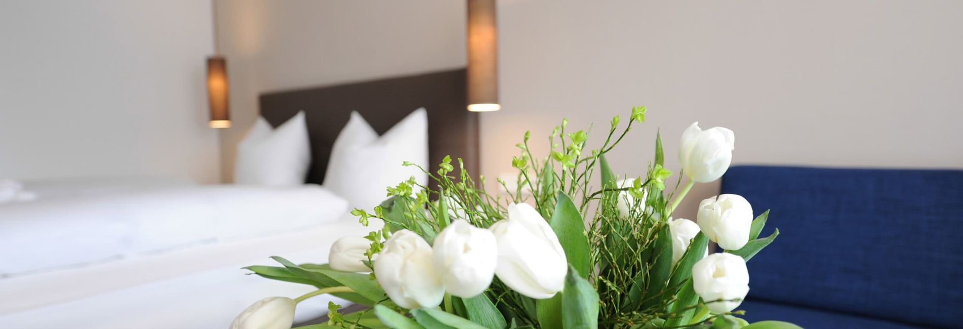 Double room Burgundy detail view with bed and cozy bedroom at Vier Jahreszeiten hotel Double room Burgundy detail view with bed and cozy bedroom at Vier Jahreszeiten hotel