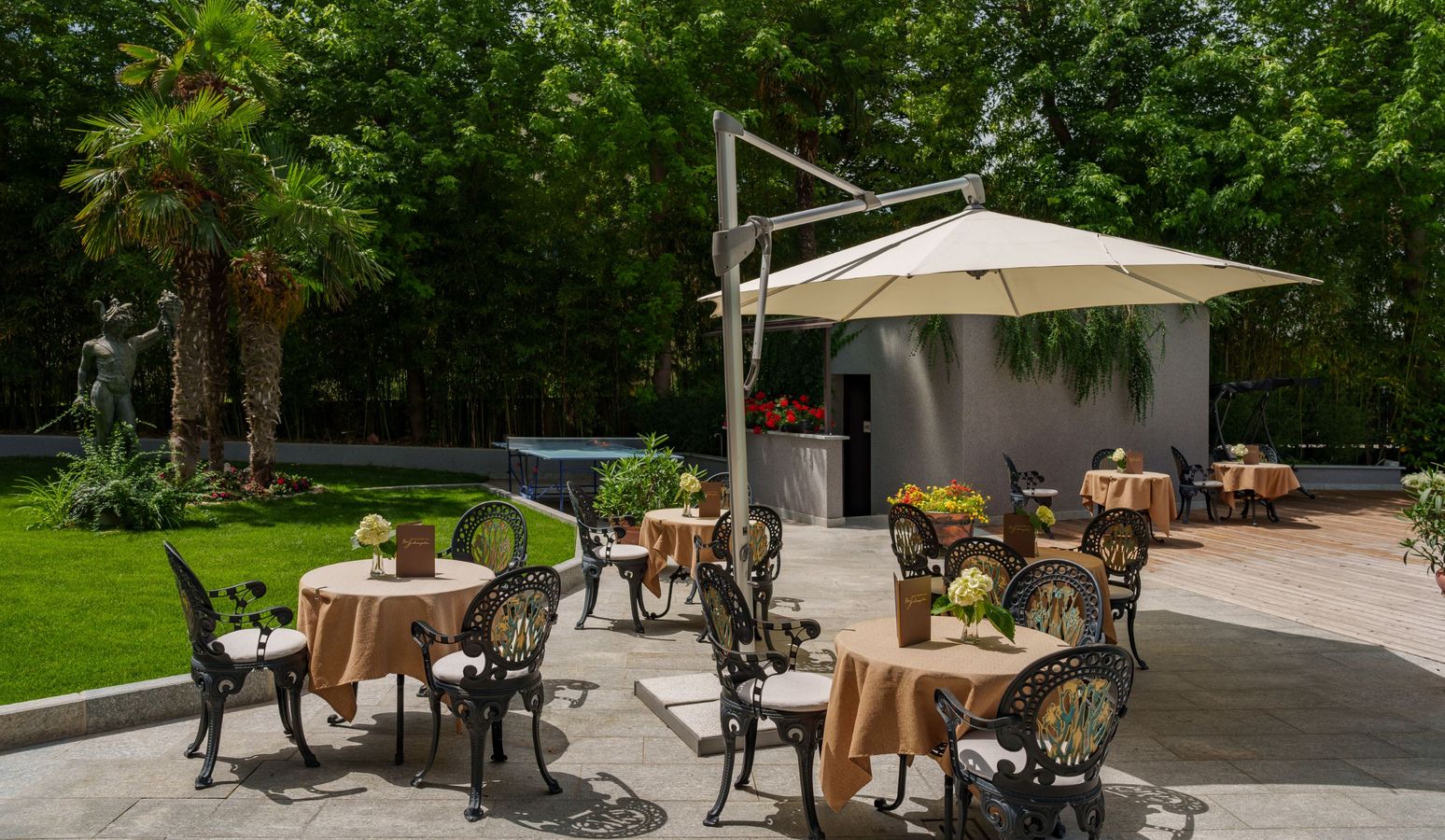 Terrasse und Garten des Hotels Vier Jahreszeiten in Schlanders bei sonnigem Wetter Terrasse und Garten des Hotels Vier Jahreszeiten in Schlanders bei sonnigem Wetter
