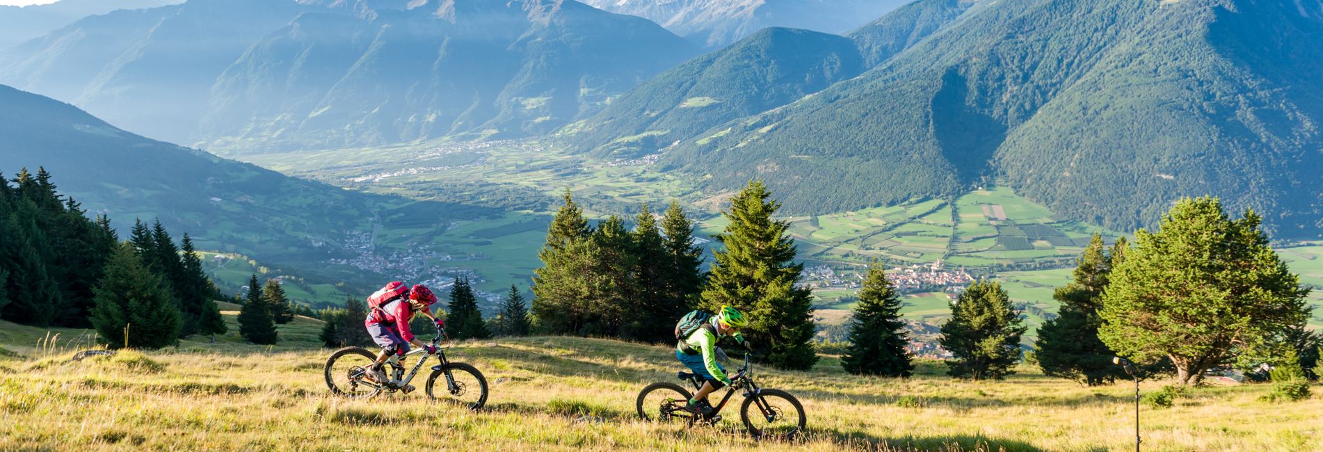 Cyclists riding bikes in scenic Vinschgau Valley near Vier Jahreszeiten Hotel in South Tyrol Cyclists riding bikes in scenic Vinschgau Valley near Vier Jahreszeiten Hotel in South Tyrol