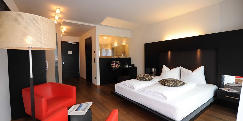 Designer penthouse bedroom at Vier Jahreszeiten hotel with modern interior and panoramic window