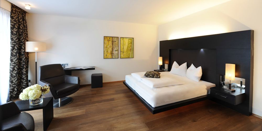 Penthouse designer suite Burgund bedroom with double bed at Vier Jahreszeiten hotel