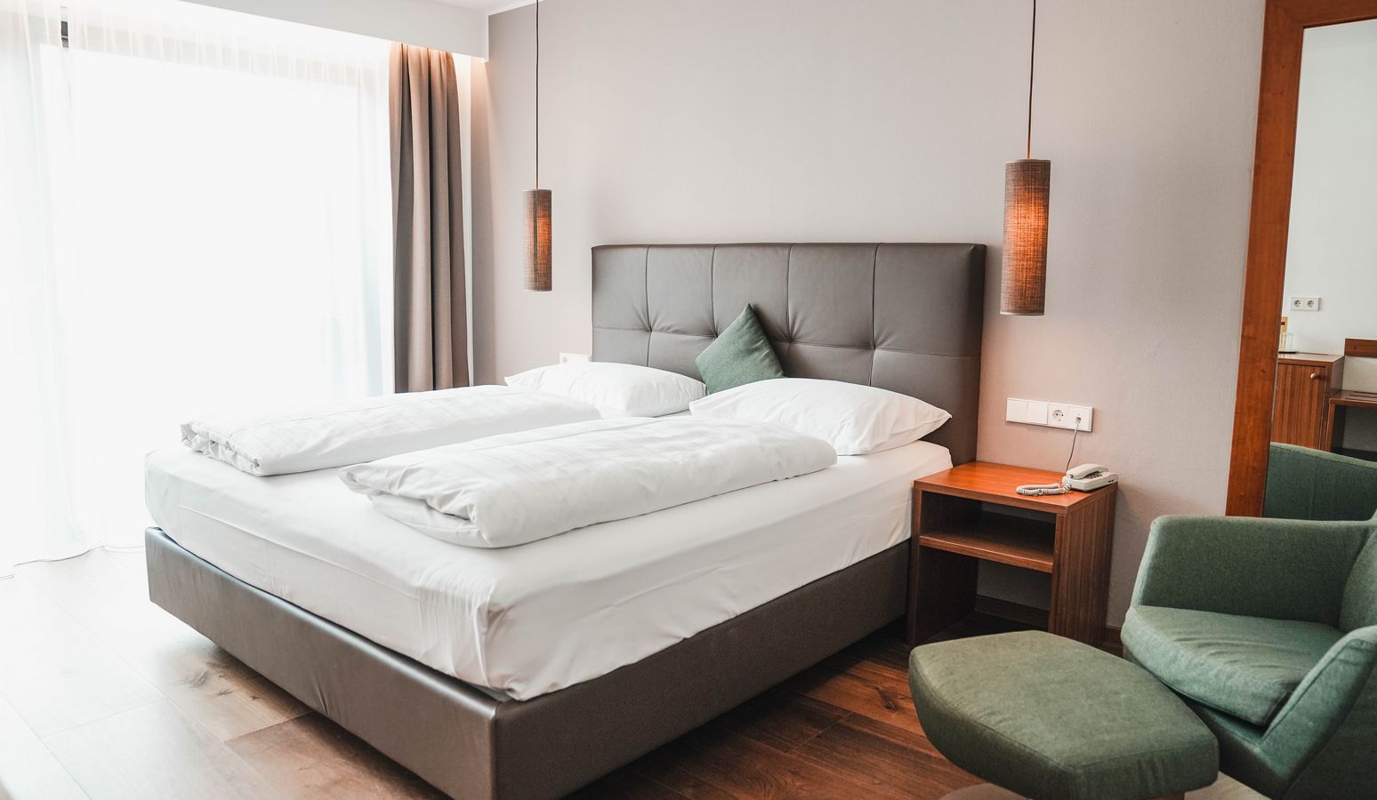 Camera d'albergo accogliente con letto matrimoniale e arredamento moderno all'Hotel Vier Jahreszeiten a Silandro Camera d'albergo accogliente con letto matrimoniale e arredamento moderno all'Hotel Vier Jahreszeiten a Silandro