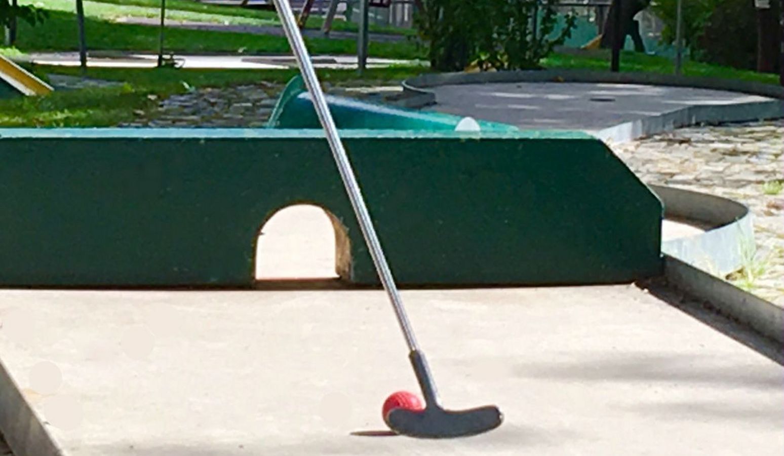 Familie spielt Minigolfanlage im Freien im Hotel Vier Jahreszeiten in Südtirol