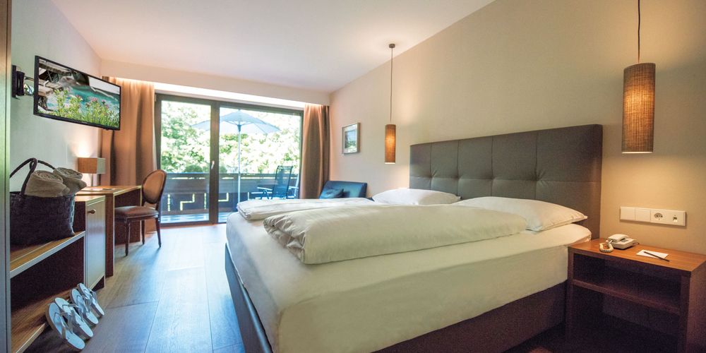 Double room Burgundy with cozy bed at Hotel Vier Jahreszeiten South Tyrol