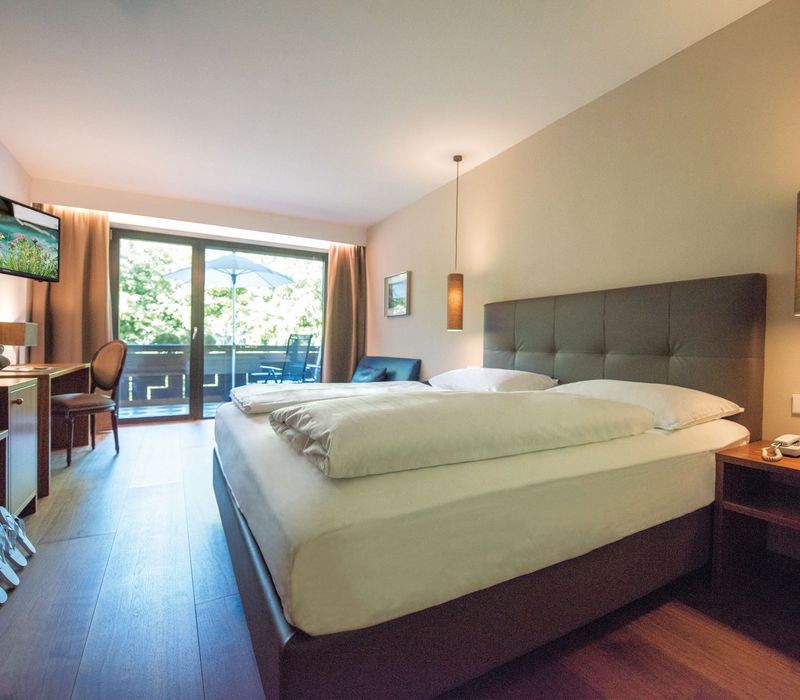 Camera doppia Burgund con letto matrimoniale e arredo accogliente all’Hotel Vier Jahreszeiten